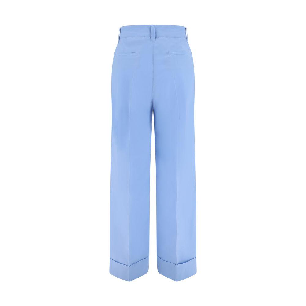 Back view of blue P.A.R.O.S.H. cotton pants with turned-up hem, button and zipper closure, side slash pockets, and back welt pockets.