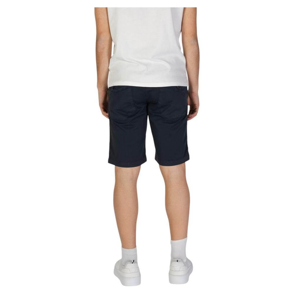 Man wearing Refrigiwear blue cotton shorts from Fall/Winter collection, back view showing knee-length fit and comfortable design.