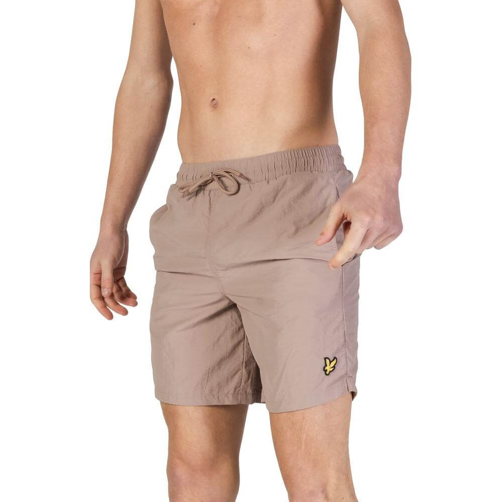 Man wearing Lyle & Scott gray nylon swimwear shorts, showcasing fall/winter men's bathing suit collection.