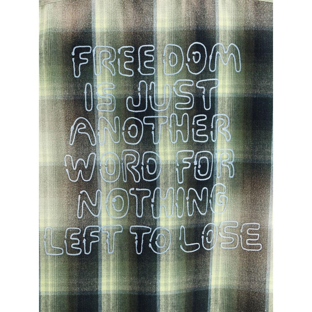 Maison Mihara Yasuhiro oversized shirt with embroidered text 'Freedom is just another word for nothing left to lose' on plaid fabric.