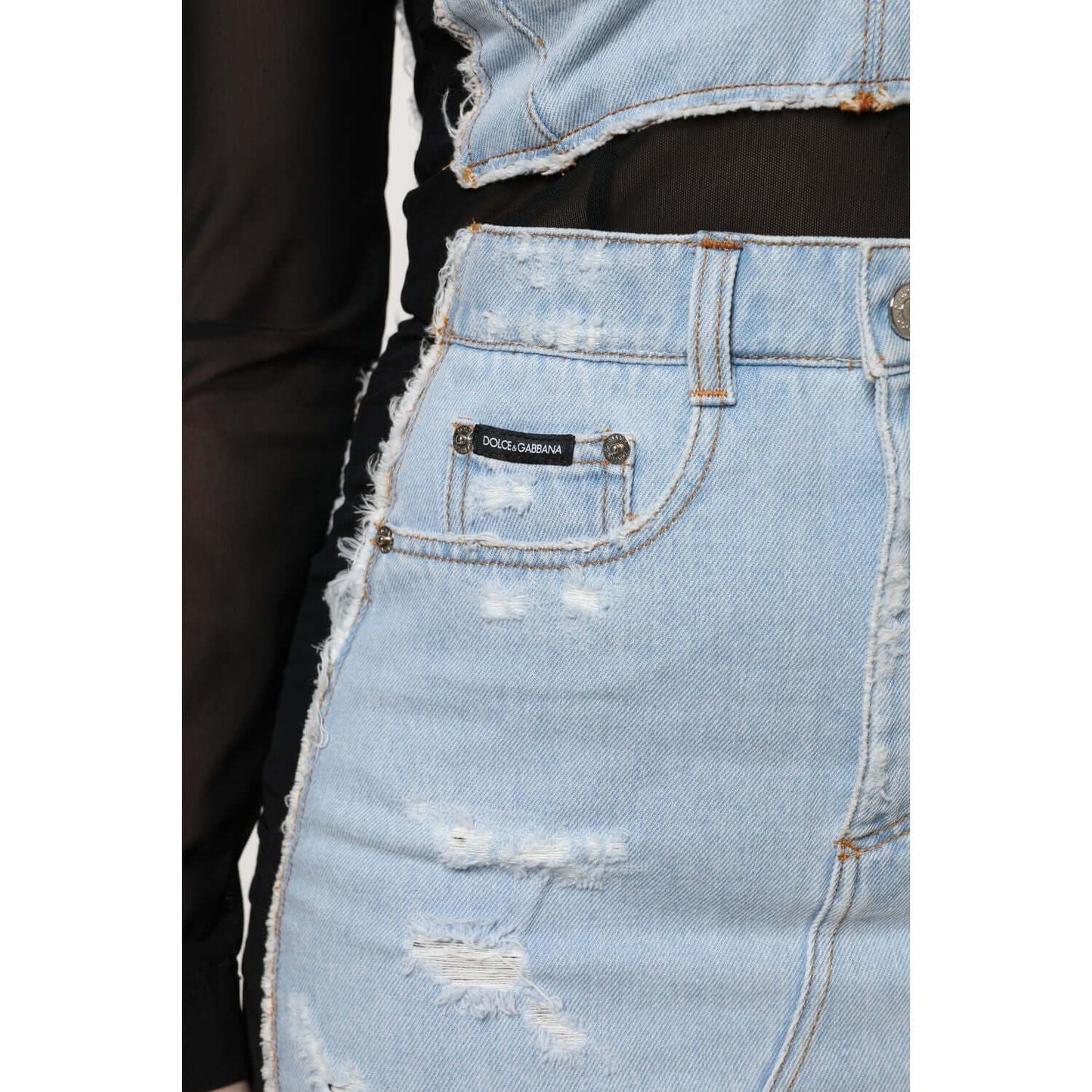 Close-up of Dolce & Gabbana blue denim mini dress with logo and distressed details. Complete outfit shown.