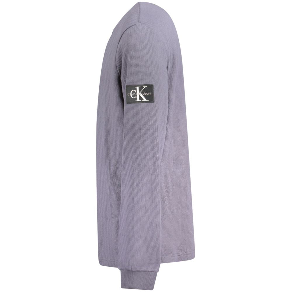 Calvin Klein blue cotton men's sweater with appliqué detail on sleeve and logo, side view. Stylish and comfortable design.