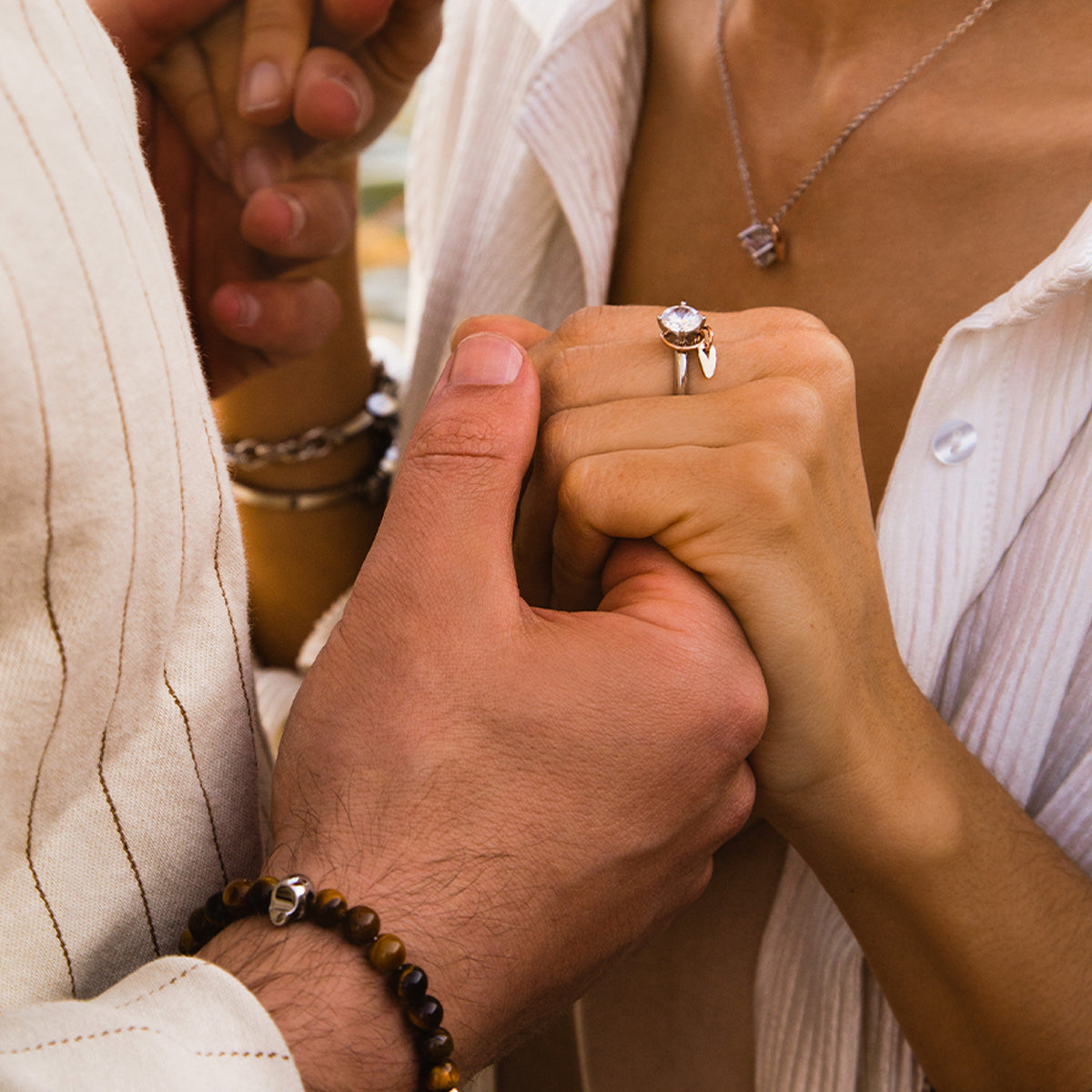 Couple holding hands showcasing engagement ring, a perfect display of love and commitment, highlighting AN JEWELS JEWELRY Mod. AL.RLFY01-9.