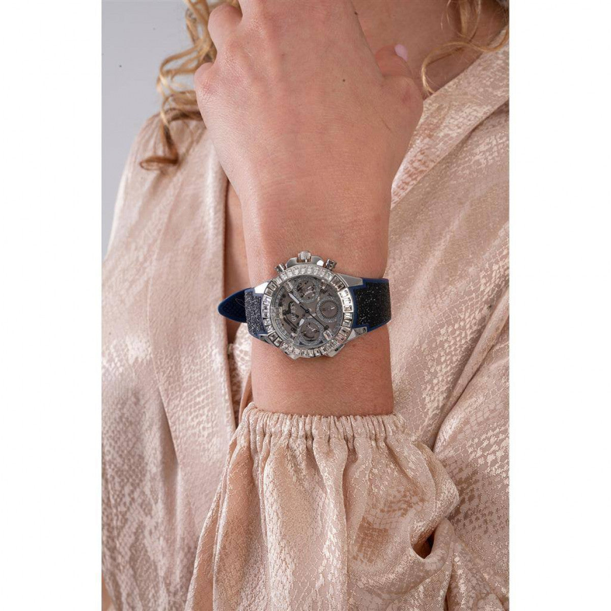 Lady wearing GUESS Mod. GW0313L1 watch, silver material, quartz analog movement, 5 ATM water resistant, in official packaging.