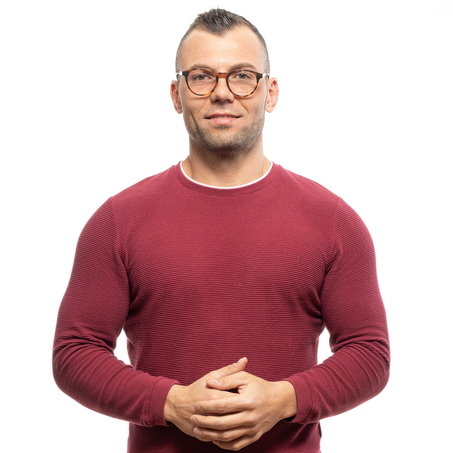 Man wearing a red sweater and glasses standing confidently.