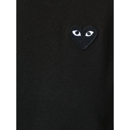 Black Comme des Garcons T-shirt with almond-eyed heart logo on chest.