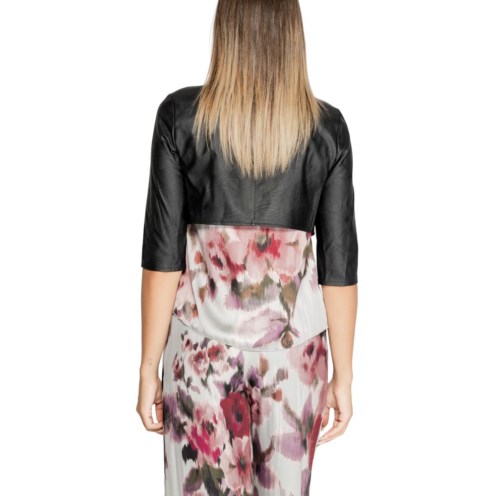 Back view of Rinascimento Black Polyethylene Cardigan over floral dress, showcasing short sleeves and open front cut for elegant look.