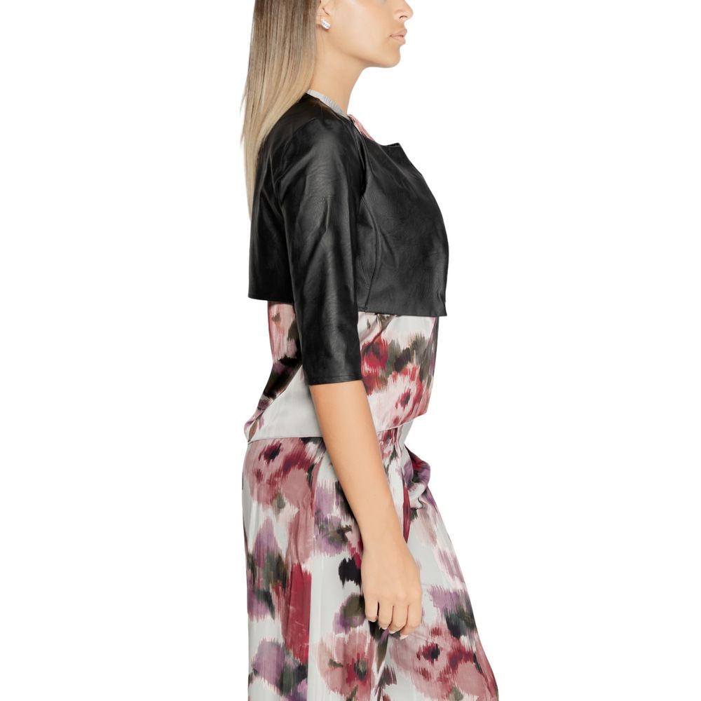 Model wearing Rinascimento Black Polyethylene Cardigan over floral dress, showcasing elegant and modern style.