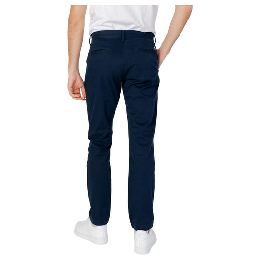 Man wearing Tommy Hilfiger blue organic cotton tapered pants, spring/summer collection. Back view showing full-length jeans.