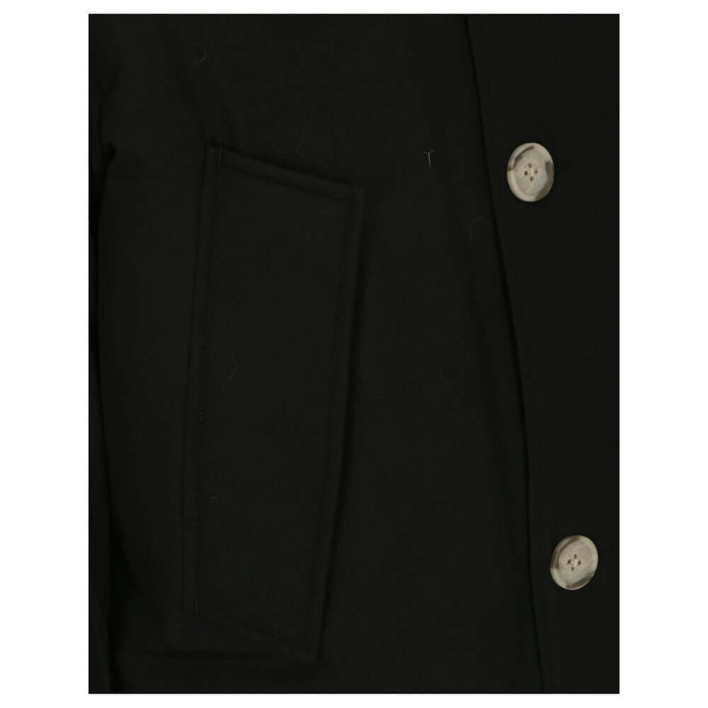 Close-up of Woolrich Black Cotton Parka showing buttons and pocket detail.