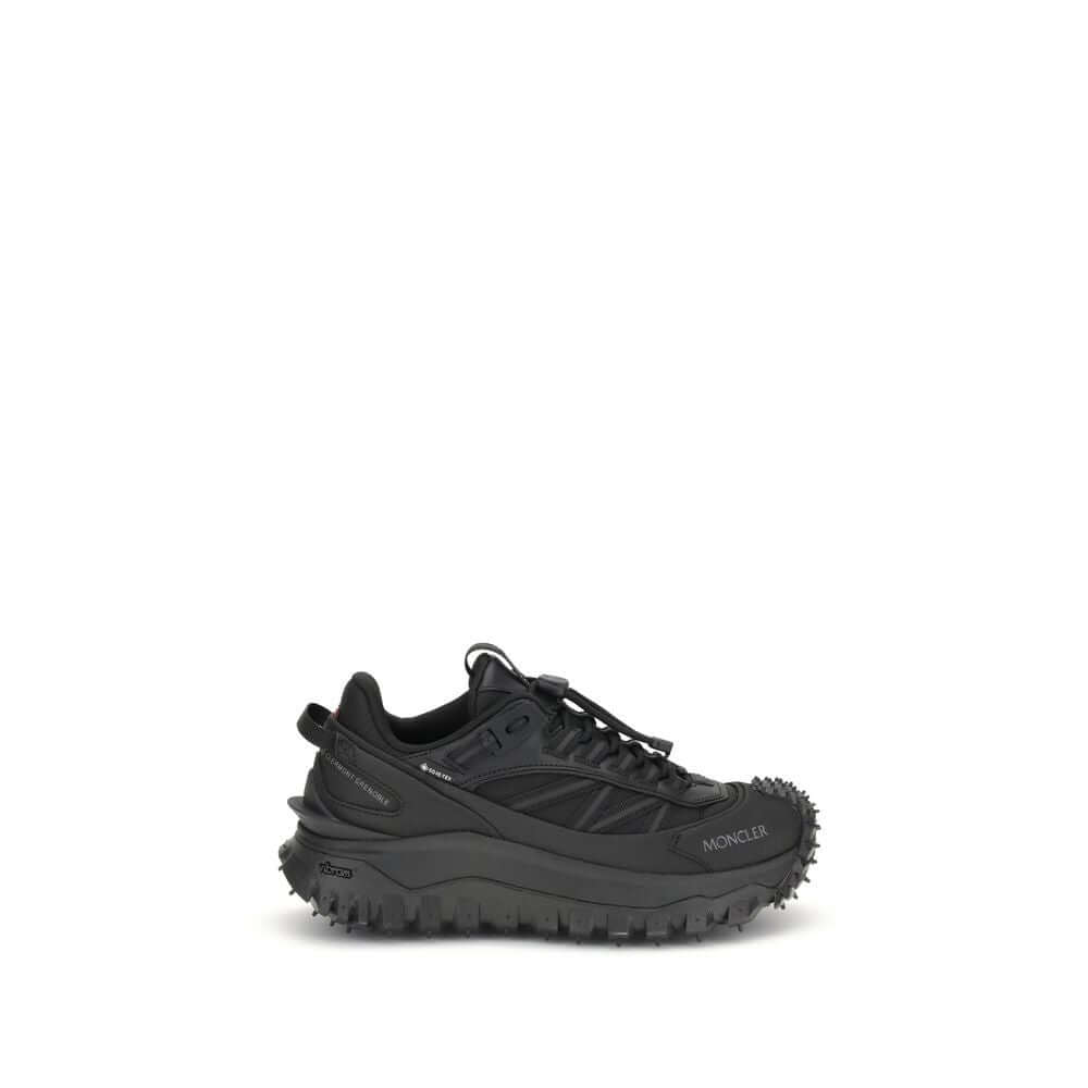 Moncler Black Calf Leather Bos Taurus Athletic Sneakers with reflective inserts and logo, side view on white background.