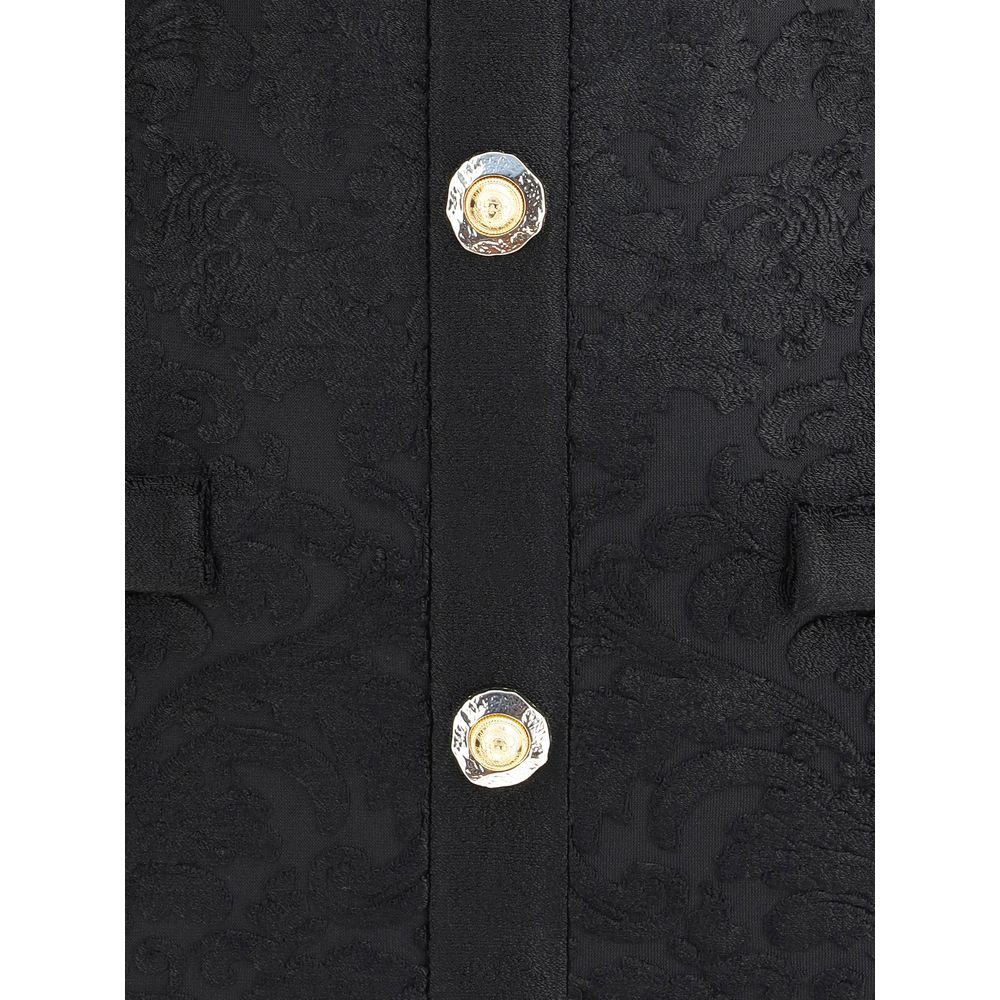 Close-up of Balmain Black Viscose Cocktail Dress with gold buttons and baroque pattern.