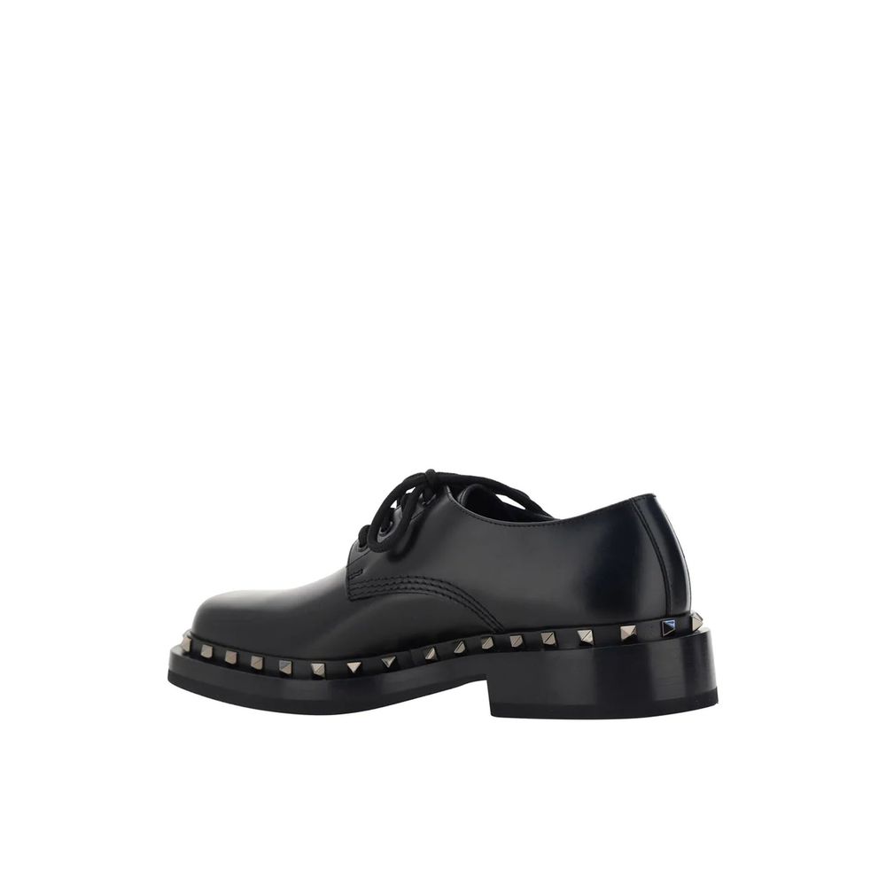 Valentino Garavani Black Calfskin Oxfords And Derbies with studs detail and lace-up closure, side view on white background.