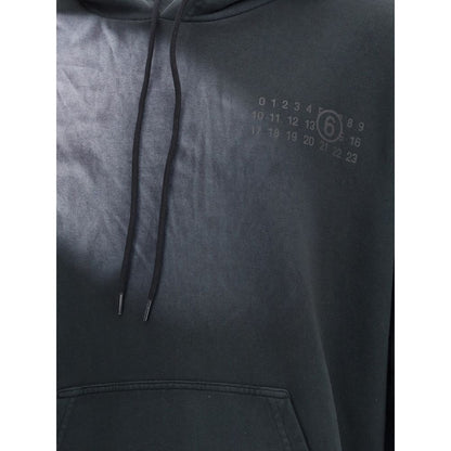 MM6 Black Cotton Sweatshirt with hood, kangaroo pocket, and relaxed fit for AW25. Made from 100% Cotton for stylish comfort and versatility.