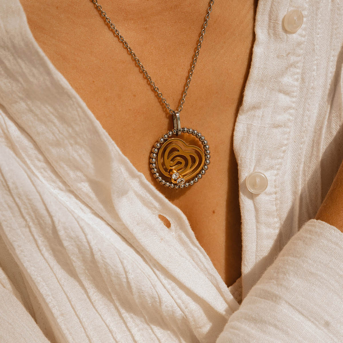 Close-up of AN JEWELS JEWELRY Mod. AL.NSOKLSYC pendant on a white shirt