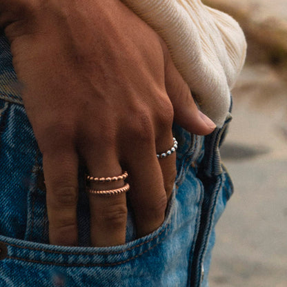 AN JEWELS JEWELRY Mod. AR.R2NS04R-8 rings on a hand in jeans pocket outdoors.