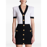 Balmain Two-tone twisted knit bodycon dress with V-neck and button details.