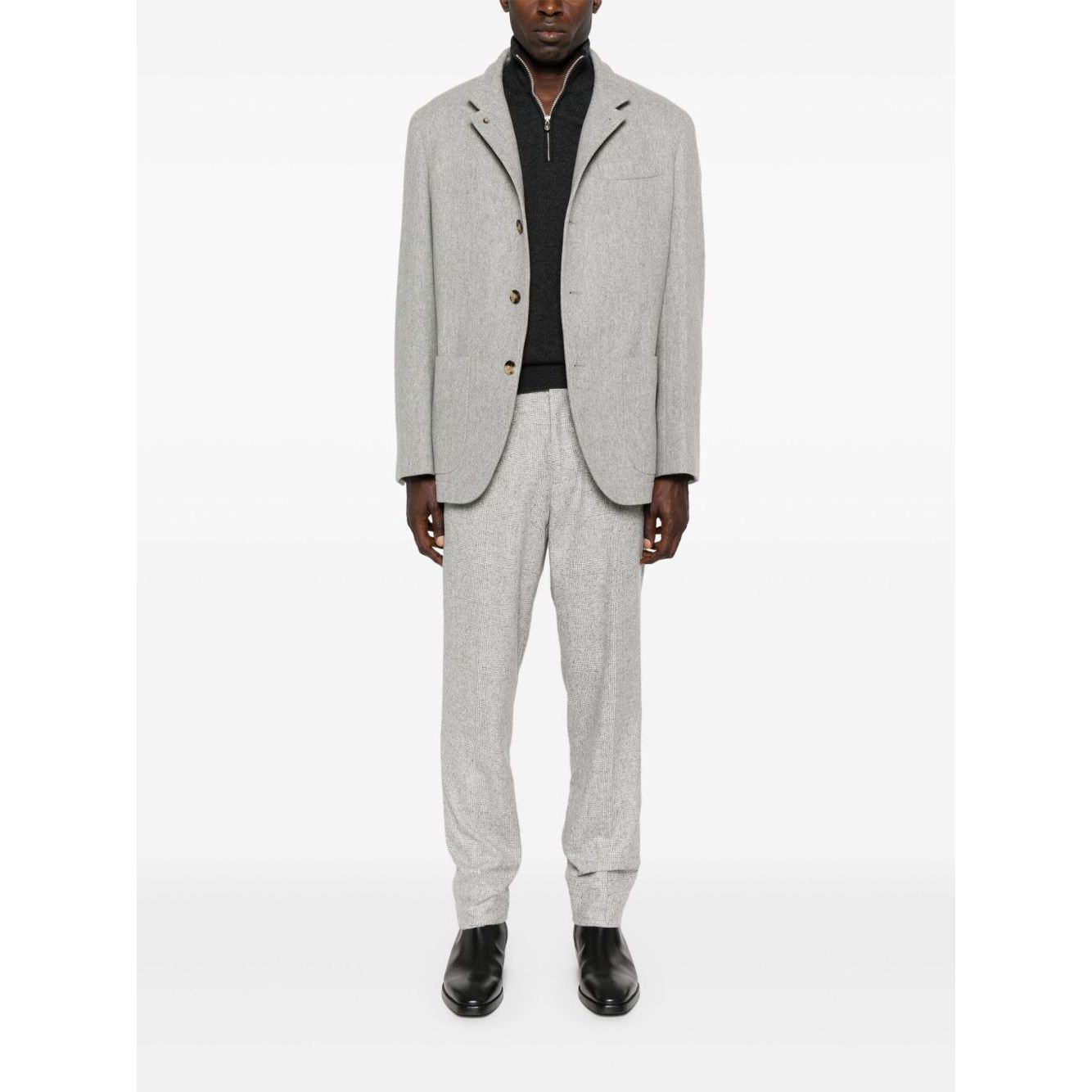 Man wearing a Brunello Cucinelli Cashmere sweater with a grey suit, showcasing a stylish outfit including a high-neck sweater and blazer.