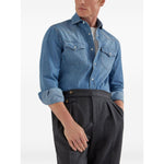 Man wearing a blue denim shirt with rolled-up sleeves and gray high-waisted trousers.