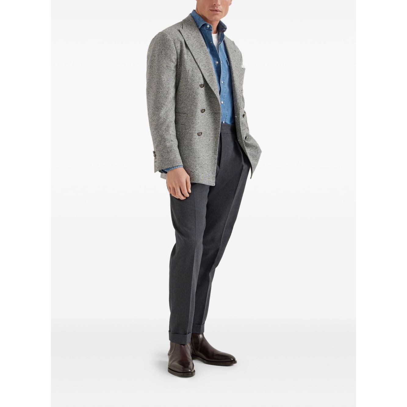 Man wearing a grey double-breasted blazer with a blue shirt and dark trousers, showcasing a smart-casual outfit.