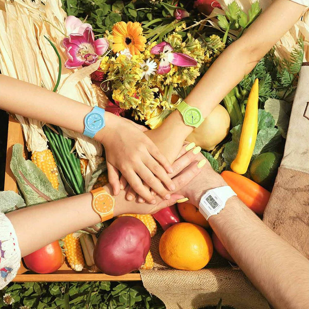 Hands wearing colorful watches over vegetables and flowers, featuring CASIO TIMELESS COLLECTION Mod. POP - BIO RESIN STRAP - LEMON GREEN.