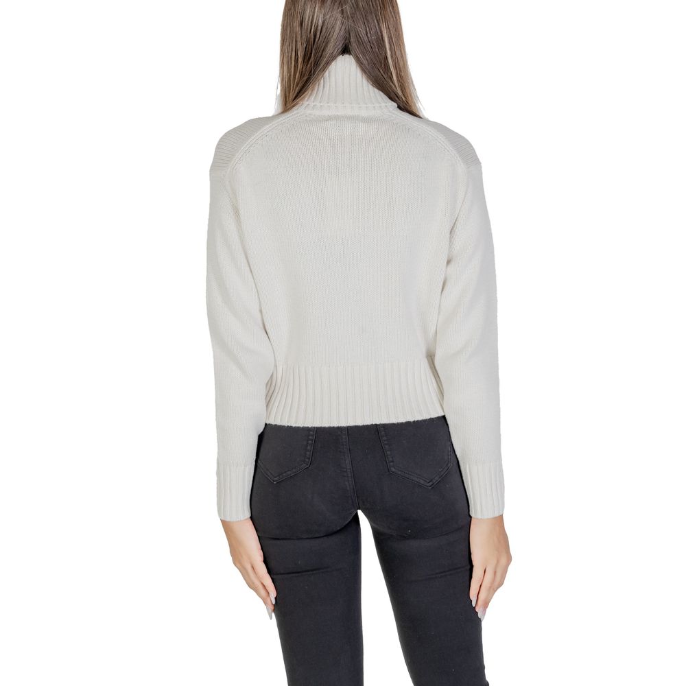 Back view of model wearing Calvin Klein Jeans Cream Cotton Sweater with ribbed turtleneck, emphasizing modern style and iconic CK logo.