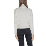 Back view of model wearing Calvin Klein Jeans Cream Cotton Sweater with ribbed turtleneck, emphasizing modern style and iconic CK logo.