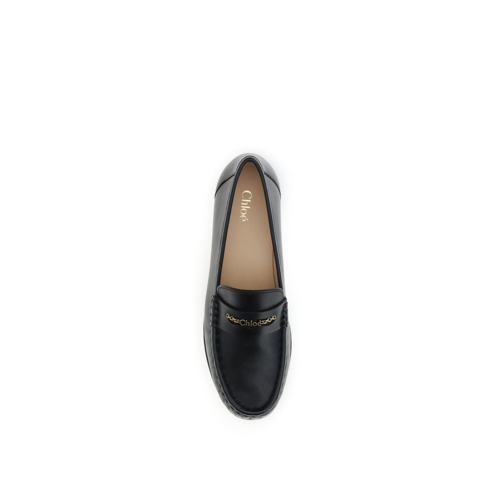Chloé Black Calf Leather Bos Taurus Slip-On Loafers with gold chain detailing and pleated design. Stylish AW25 fashion footwear for women.