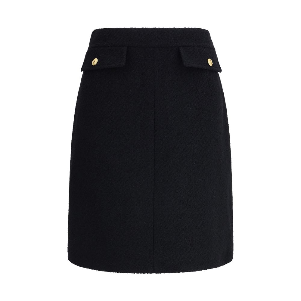 Chloé Black Wool Midi Skirt with bouclé texture and gold-tone buttons, features front flap pockets and side zip for a sleek fit.