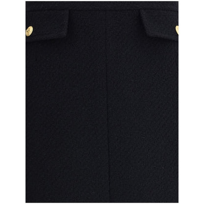 Close-up of Chloé Black Wool Midi Skirt with gold-tone buttons and front flap pockets, crafted from premium bouclé wool.