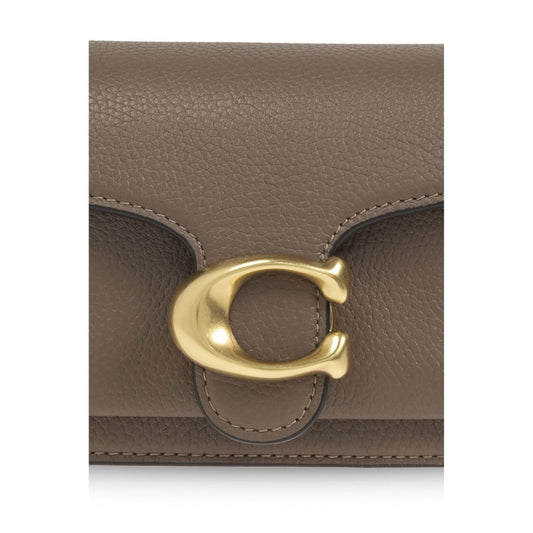 Close-up of Coach Tabby 20 shoulder bag with gold-tone clasp detail on brown leather exterior.