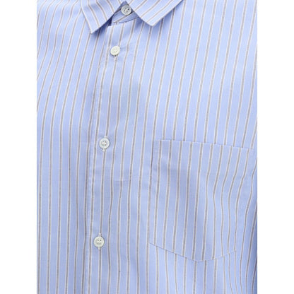 Comme Des Garçons Light Blue Cotton Pattern Shirt with subtle stripes and double cuffs, showcasing refined elegance and avant-garde style.