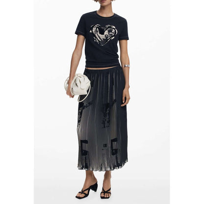 Woman wearing Desigual Black Polyester Women Skirt with newspaper motifs and elastic waist, styled with a t-shirt and sandals.