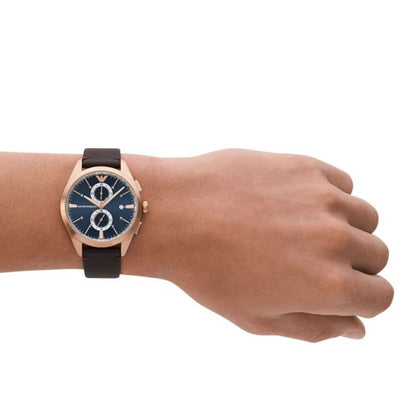 EMPORIO ARMANI Mod. CLAUDIO wristwatch with leather strap and rose gold case on wrist, showcasing its elegant design.