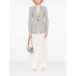 Model wearing Emporio Armani Icon Blazer in light grey with front button fastening and side welt pockets, styled with wide-leg trousers.