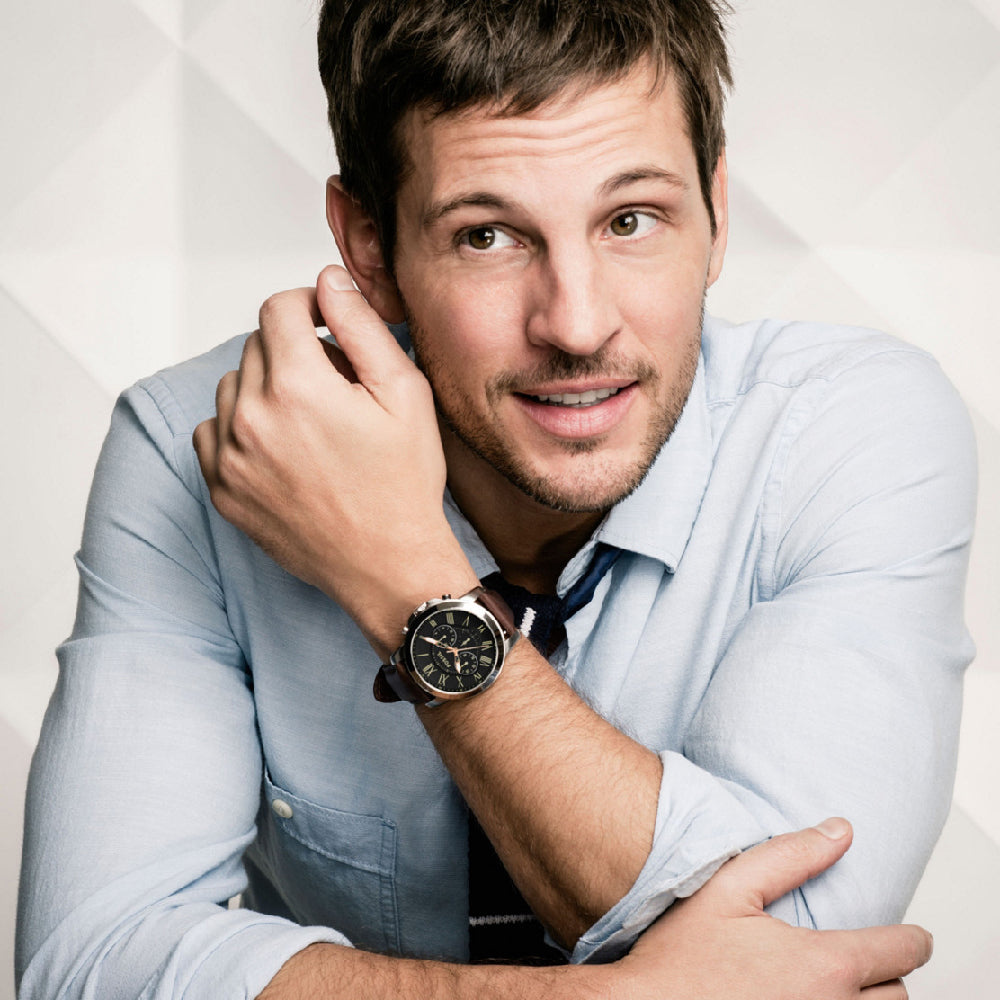 Gent wearing FOSSIL WATCHES Mod. FS4813 with stainless steel case and leather strap, 5 ATM water resistant, in a stylish pose.