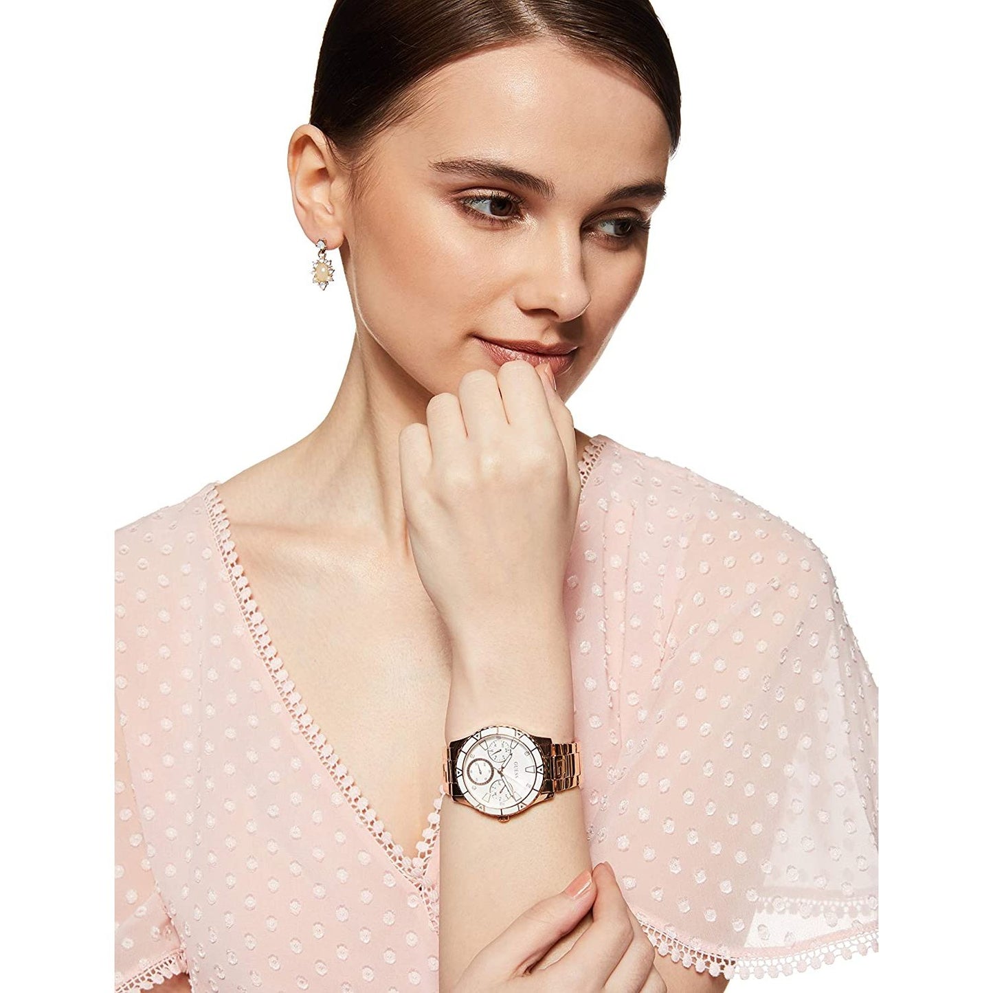 Woman wearing GUESS Mod. W1158L2 quartz analog watch, silver material, 38mm case, with mineral dial. Elegant accessory for ladies.