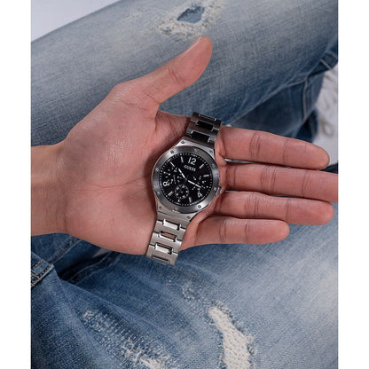 GUESS Mod. GW0454G1 quartz analog watch for men with silver 925° material, shown in a hand with official packaging.