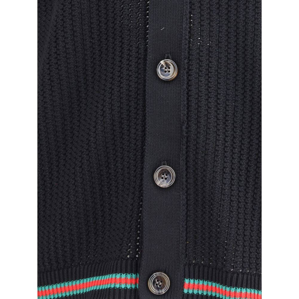 Close-up of Gucci Black Cotton Cardigan showcasing textured knit weave, button closure, and ribbed hem detail.