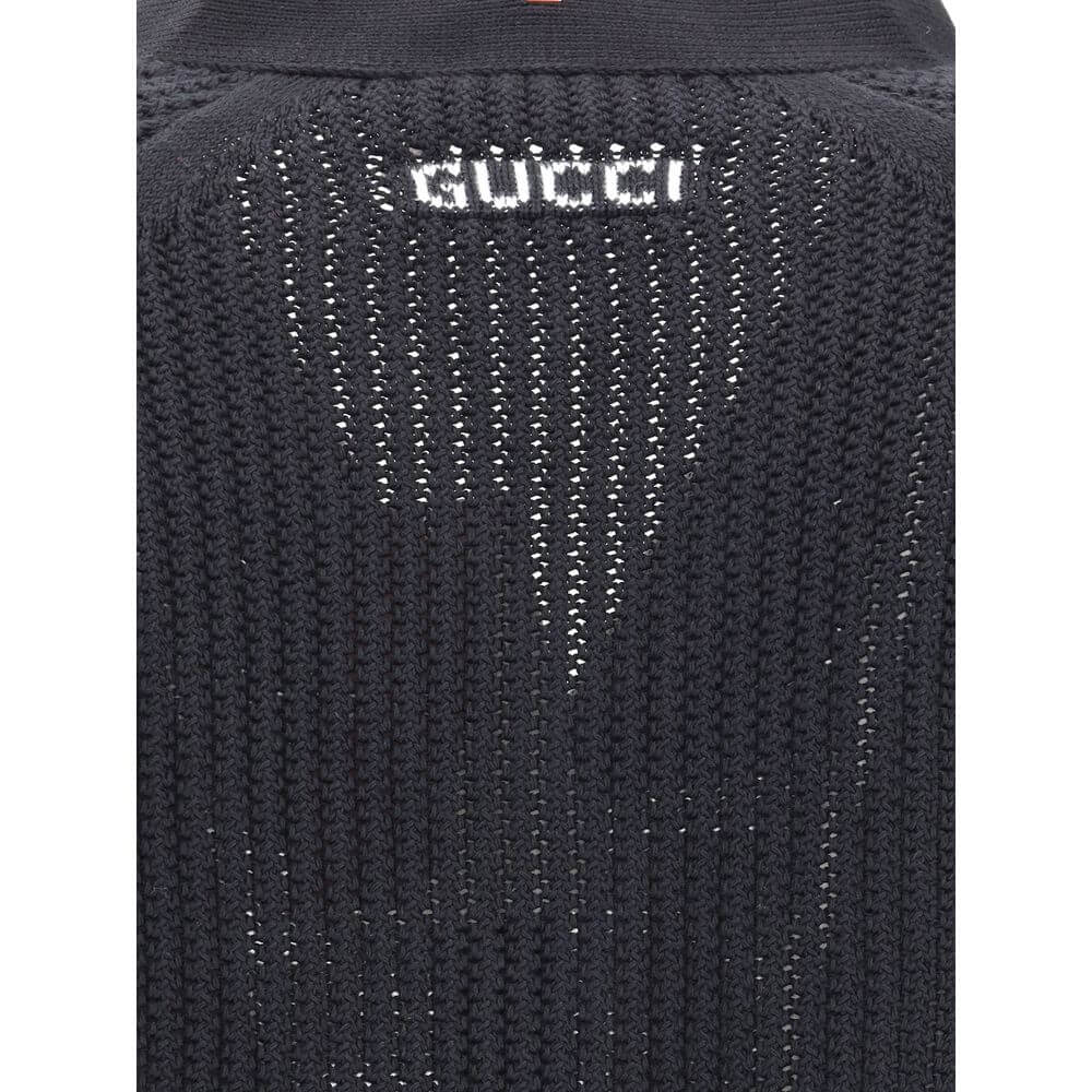 Back detail of Gucci Black Cotton Cardigan featuring knit weave and Gucci logo, showcasing texture and branding.