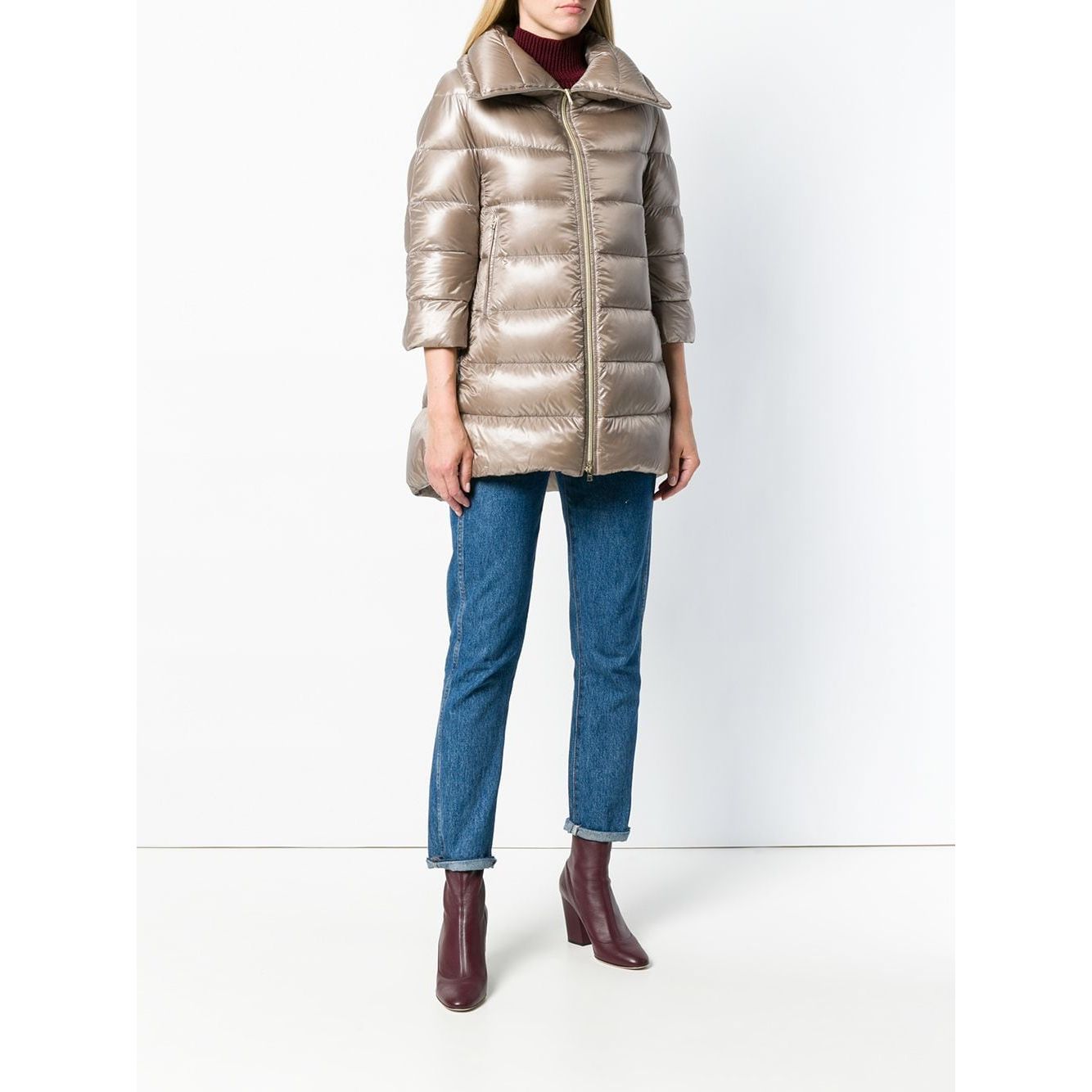 Woman wearing Herno Coats Dove Grey nude feather down padded zipped coat, Cleofe midi style, styled with jeans and boots, front view