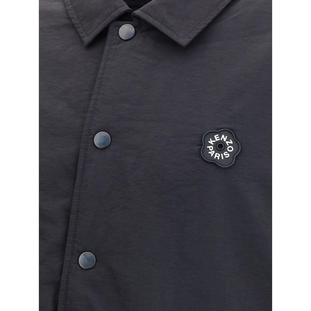 Close-up of Kenzo Black Nylon Bomber jacket featuring metal button closure and Kenzo Boke Flower 2.0 rubber logo on black matte fabric.