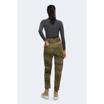 Back view of woman wearing gray polyester turtleneck and camo pants, showcasing casual style and comfort.