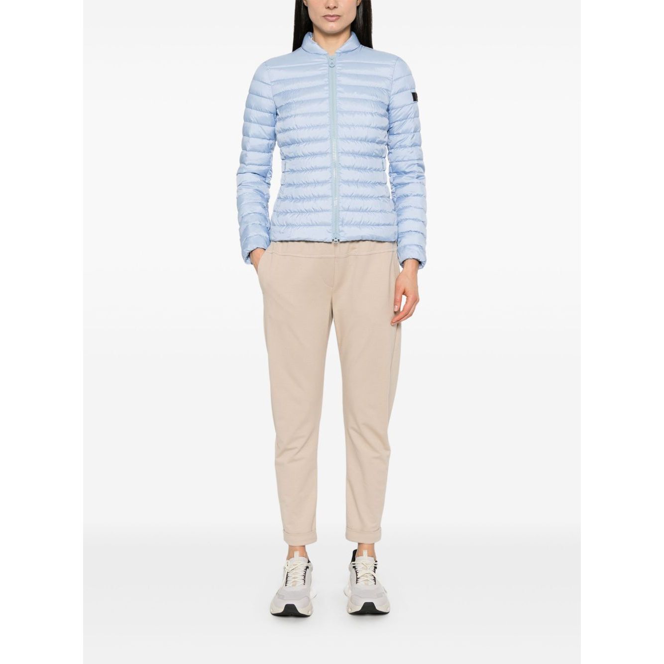Model wearing Peuterey Coats Clear Blue, lightweight sky blue quilted jacket with two-way zip, pockets, and logo patch.