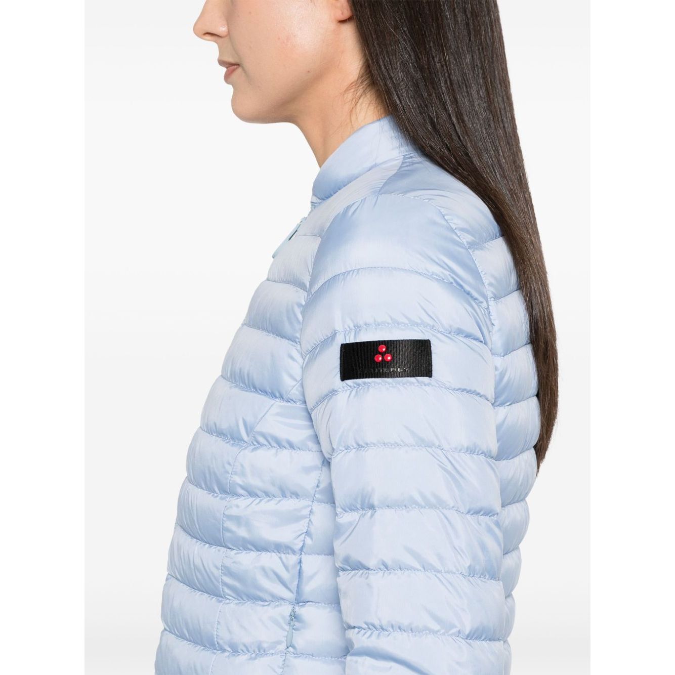 Side view of Peuterey Coats Clear Blue lightweight nylon quilted jacket with logo patch and zip pockets.