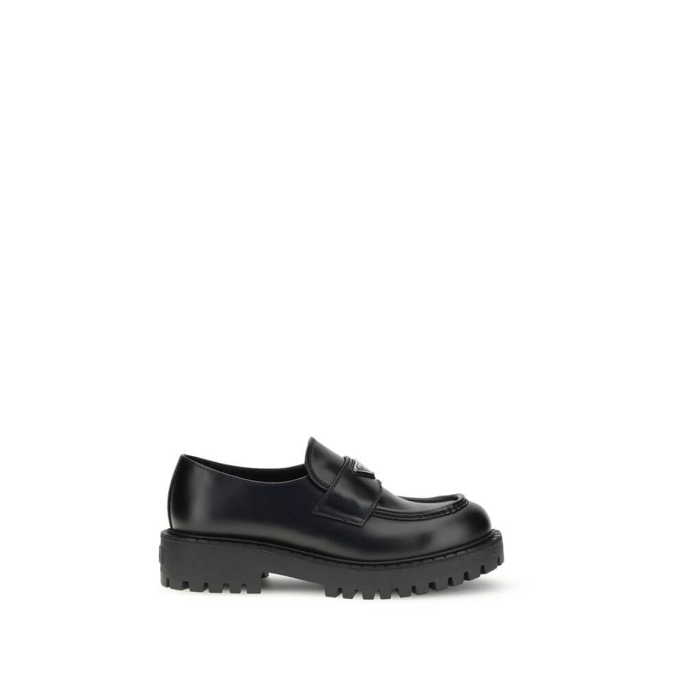 Prada Black Calf Leather Bos Taurus Slip-On Loafers with enameled triangle band and rubber sole.