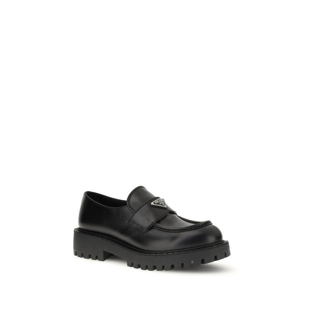 Prada Black Calf Leather Bos Taurus Slip-On Loafers with enameled triangle logo and rubber sole.
