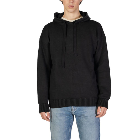 Man wearing Underclub Black Cotton Sweater with drawstring hood and ribbed cuffs, showcasing modern knitwear style and comfort.