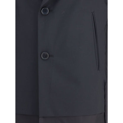 Undercover Black Polyester Coat with paneled design and two-button closure, featuring classic lapels and welt pockets. AW25 collection.
