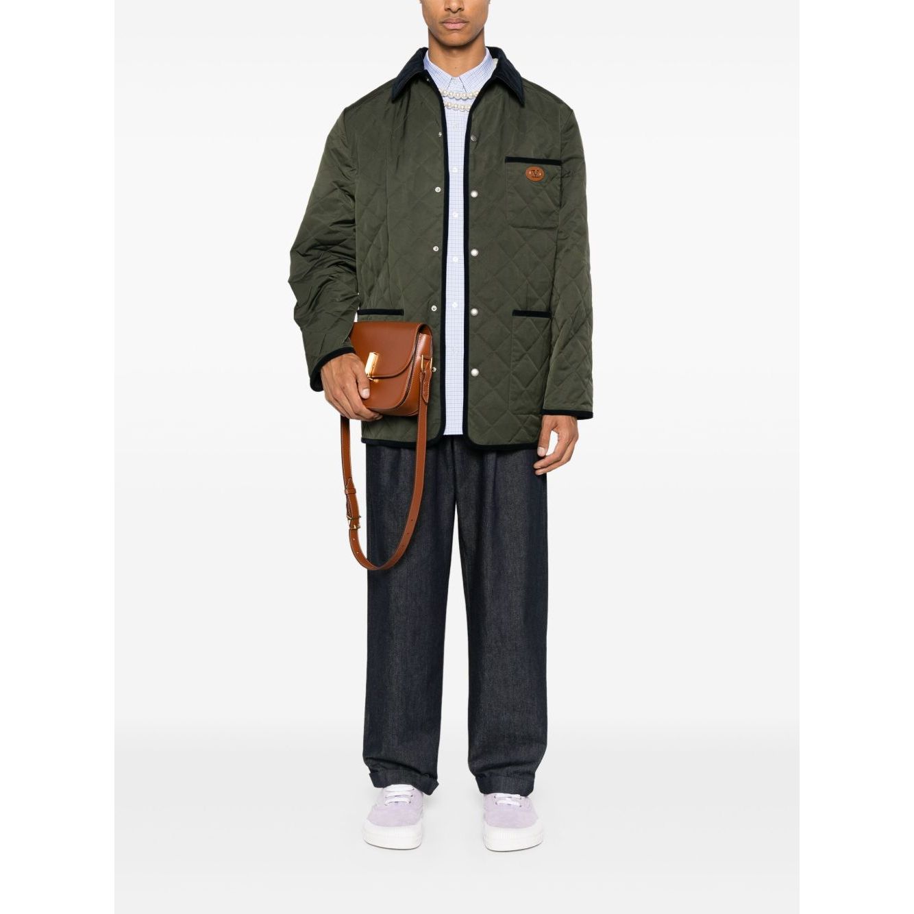 Model wearing Valentino Vlogo Signature quilted jacket in olive with contrasting collar and trim, featuring three front patch pockets.